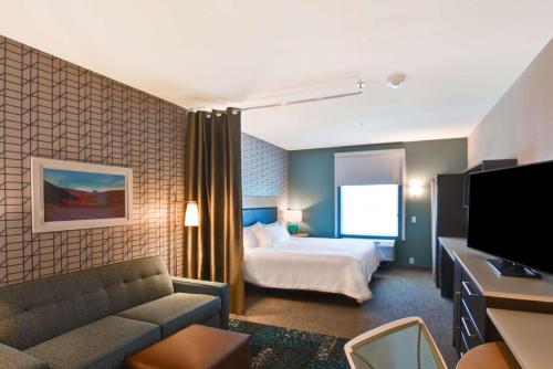 um quarto de hotel com uma cama e um sofá em Home2 Suites By Hilton Palmdale em Palmdale