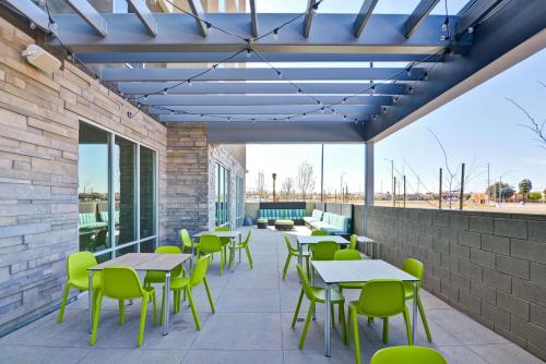 a patio with tables and chairs on a building at Home2 Suites By Hilton Palmdale in Palmdale