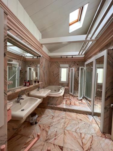 uma casa de banho com dois lavatórios e dois espelhos em Luxury Villa con Piscina y Tenis em Argés