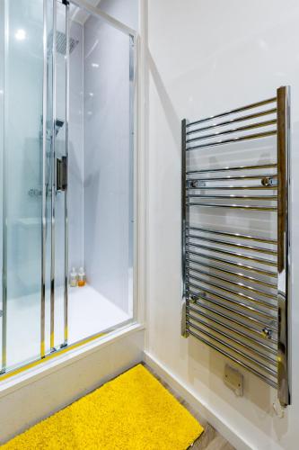 a bathroom with a shower and a yellow rug at City Centre Vintage Chic Studio in Manchester