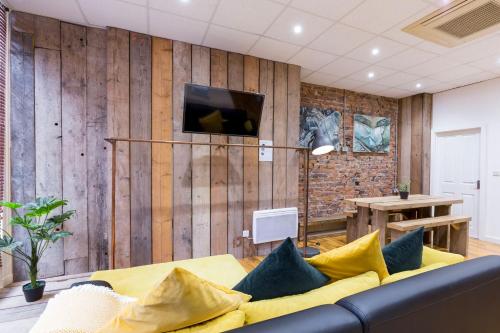 a living room with a couch and a tv on a wall at City Centre Vintage Chic Studio in Manchester