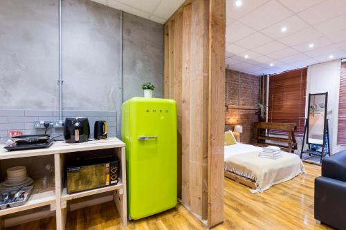 a green refrigerator in a room with a bed at City Centre Vintage Chic Studio in Manchester