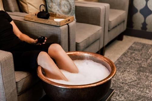 a woman is sitting in a bowl of milk at Embassy Suites By Hilton Knoxville Downtown in Knoxville