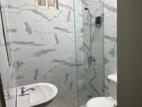 a bathroom with a shower with a sink and a toilet at Hostal 53 Boutique Santo Domingo in Santo Domingo