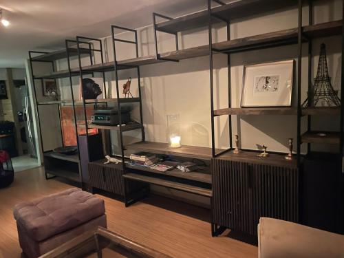 a living room filled with shelves and a chair at Departamento Delux in Santiago