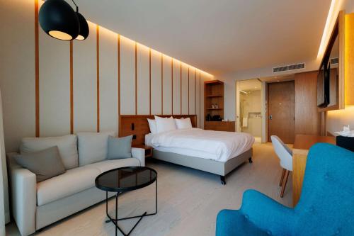 a hotel room with a bed and a couch at Radisson Beach Resort Larnaca in Larnaca