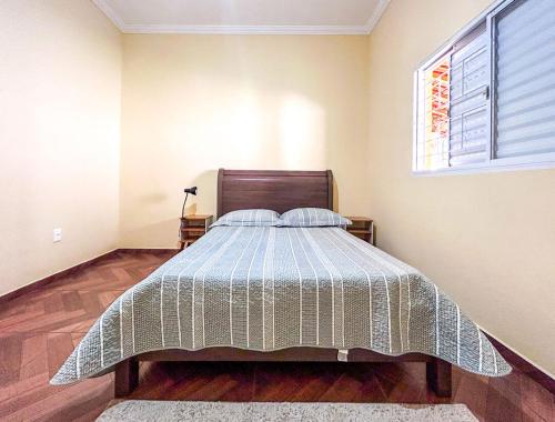 a bedroom with a bed and a window at Chacara com piscina, churrasq e WiFi em Taubate SP in Taubaté