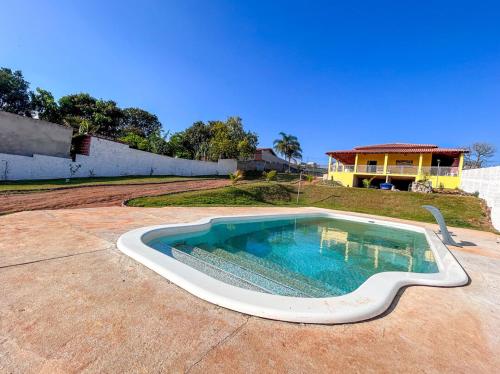 uma piscina num quintal com uma casa em Chacara com piscina, churrasq e WiFi em Taubate SP em Taubaté