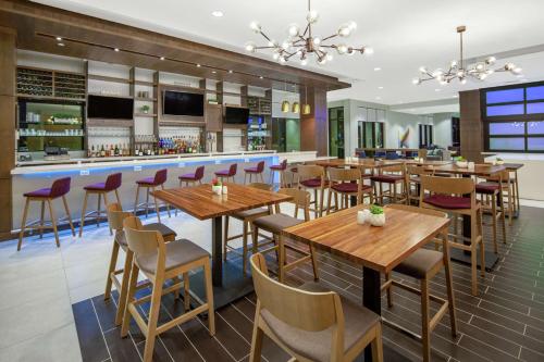 a restaurant with wooden tables and chairs and a bar at Hilton Garden Inn Surprise Phoenix in Surprise