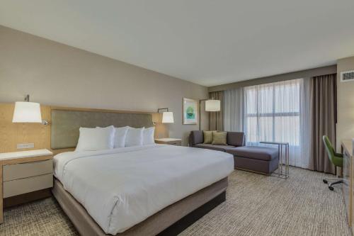 チャンドラーにあるDoubleTree by Hilton Chandler Phoenix, AZの大きなベッドとソファが備わるホテルルームです。