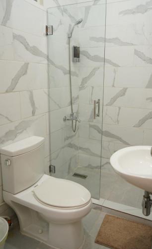 a bathroom with a toilet and a shower and a sink at Hostal 53 Boutique Santo Domingo in Santo Domingo
