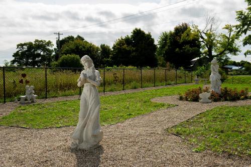 a statue of a woman standing in a garden at Villa di Casa - Boutique Hotel in Wellington