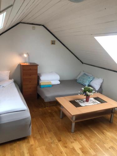 a room with two beds and a table in a attic at King size bed, hjem med utsikt, gratis parkering in Bodø