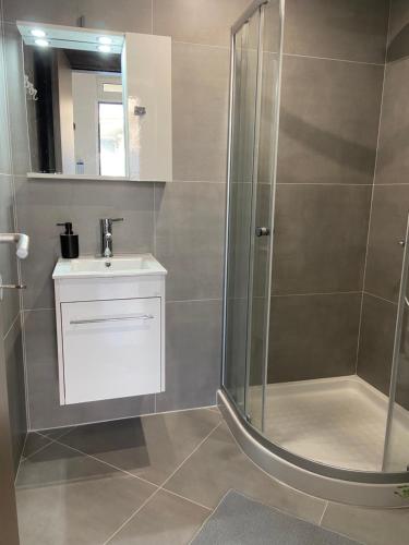 een badkamer met een douche en een wastafel bij Leo's Apartments in Koropíon