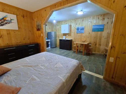 1 dormitorio con 1 cama grande en una habitación con paredes de madera en "Suite Dreams" Descanso Cerca del Mar, en El Quisco