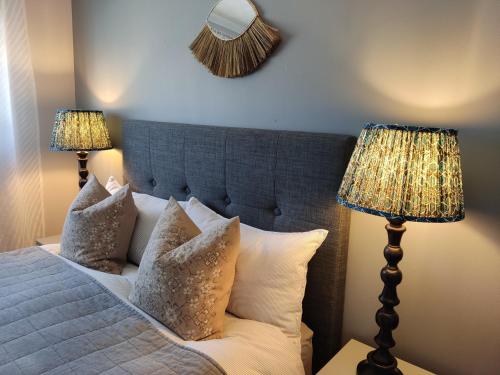een slaapkamer met een bed met kussens en 2 lampen bij Self-catering in Portree in Portree