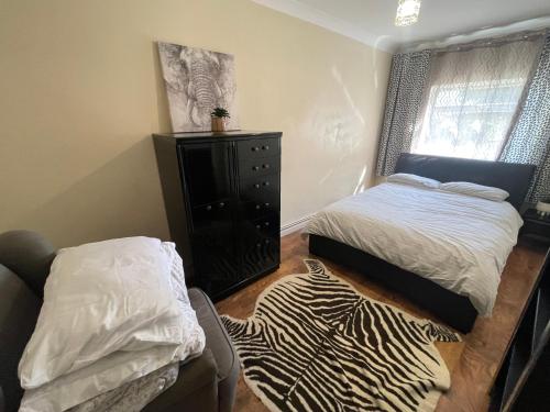 ein Schlafzimmer mit einem Bett, einem Stuhl und einem Zebra-Teppich in der Unterkunft the wood in London