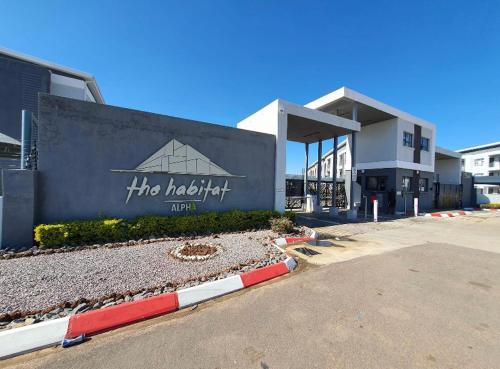 un gran edificio con un cartel delante en E105 Sarona City Flat E105, en Gaborone