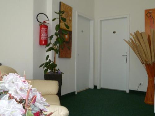 a living room with a couch and a fire extinguisher at Hotel Alpino in Malcesine