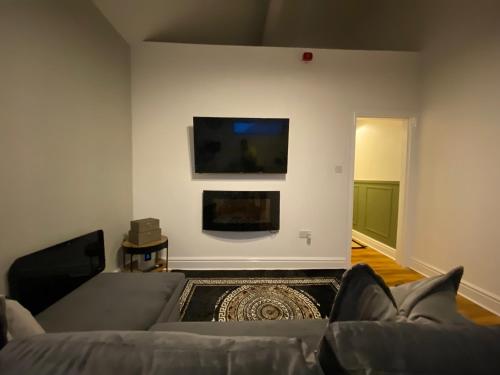 a living room with a couch and a flat screen tv at The Lofthouse in Blackpool