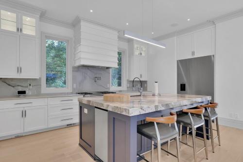 a kitchen with white cabinets and a large island with bar stools at Atl Royal in Atlanta