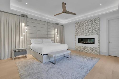 a white bedroom with a bed and a fireplace at Atl Royal in Atlanta