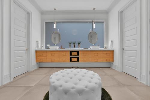 a white bathroom with a large mirror and a stool at Atl Royal in Atlanta