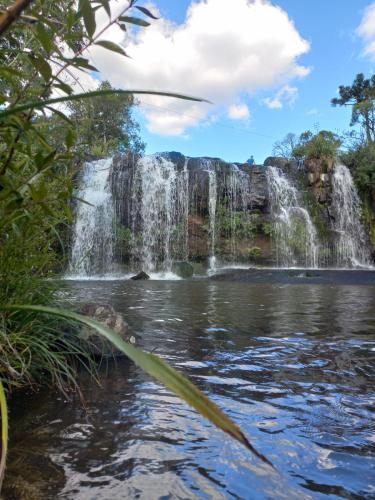 a waterfall in the middle of a pond at Pousada Recanto da Cascata - Cabana Platano in São Joaquim