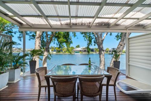 a table and chairs on a deck with a view of the water at Noosa Entrance Waterfront Resort in Noosaville
