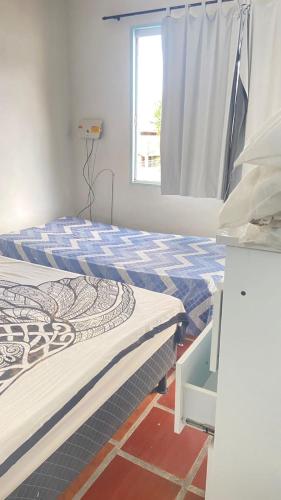 a bedroom with two beds and a window at Antonia Hospedaria 2 in Búzios