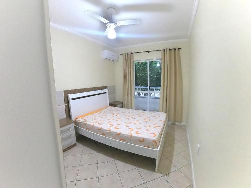 a bedroom with a bed and a ceiling fan at 124 - Apartamento 3 dormitórios condomínio fechado in Bombinhas