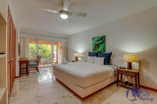 1 dormitorio con 1 cama y ventilador de techo en Chac Hal, Beachfront Apartment with Amenities - Chac Hal 2, en Puerto Aventuras