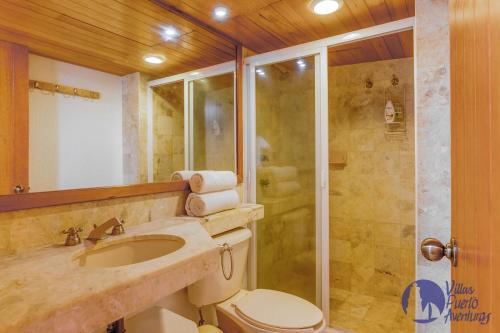 y baño con ducha, aseo y lavamanos. en Chac Hal, Beachfront Apartment with Amenities - Chac Hal 2, en Puerto Aventuras