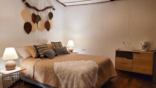 a bedroom with a bed and two lamps and a dresser at CABAÑAS EN ZONA 16 in Guatemala