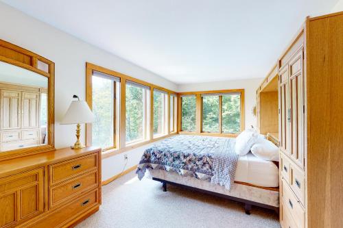 1 dormitorio con 1 cama con vestidor y ventanas en Lincoln Peak Retreat, en Warren