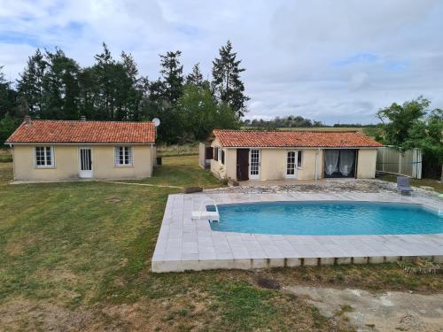 une maison avec une piscine dans une cour dans l'établissement Escapade Nature : Maison et Lofts Privés avec Piscine, Étang de Pêche et Grandes Terrasses - FR-1-591-365, à Bélâbre
