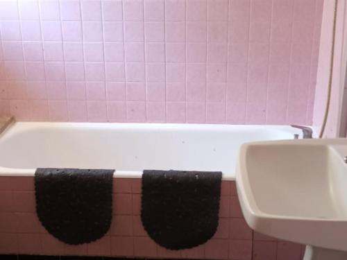 uma casa de banho com uma banheira e um lavatório em Gîte Saint-Vincent-du-Lorouër, 4 pièces, 6 personnes - FR-1-410-200 em Saint-Vincent-du-Lorouër