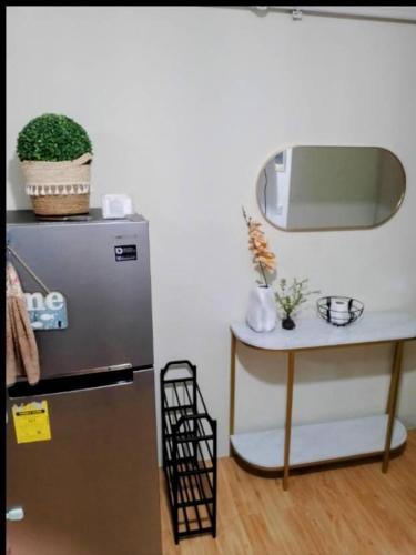 a kitchen with a refrigerator and a table with a mirror at Arezzo Place Condo in Davao City