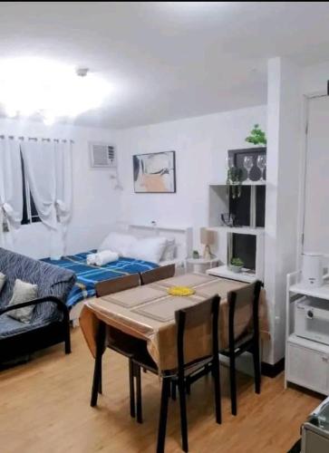 a living room with a table and a bed at Arezzo Place Condo in Davao City