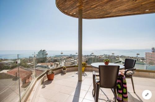 balcón con mesa, sillas y vistas al océano en Hostal lala porteña vista al mar, baño privado y desayuno en Valparaíso