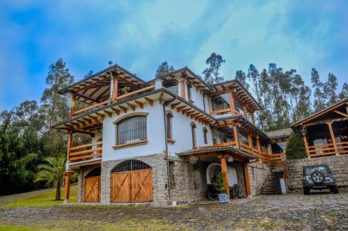 una casa con un exterior de madera y piedra en Hacienda Turística La Morería, en Amaguaña