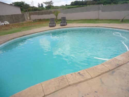 a large pool with two chairs in a yard at Noma-Nini Lodge in White River