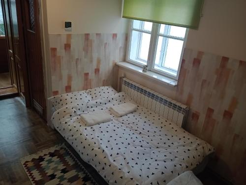 a bedroom with a bed with two pillows on it at Kawalerka. in Przemyśl