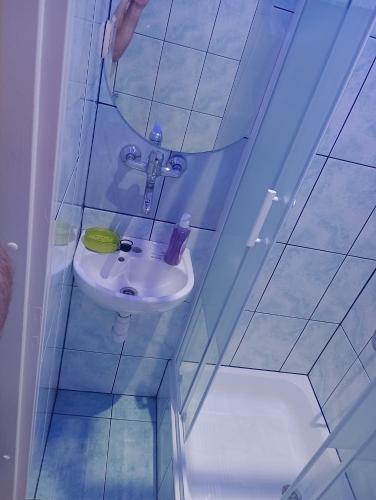 małą łazienkę z umywalką i lustrem. w obiekcie Kawalerka. w mieście Przemyśl