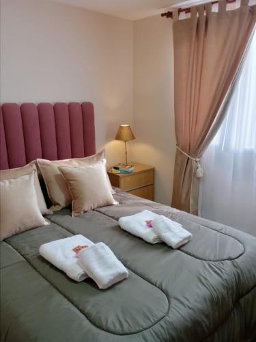 - un grand lit avec 2 oreillers blancs dans l'établissement My House in El Calafate., à El Calafate