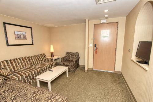 a living room with a couch and a tv at Holiday Inn Leon-Convention Center by IHG in León
