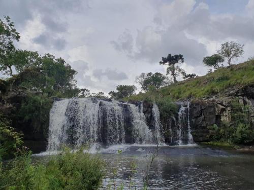 a waterfall in the middle of a pool of water at Pousada Recanto da Cascata - Cabana Liquidambar in São Joaquim
