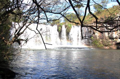 a waterfall in the middle of a body of water at Pousada Recanto da Cascata - Cabana Liquidambar in São Joaquim