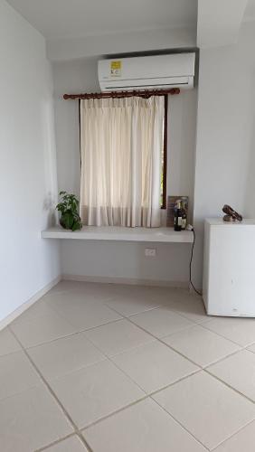 a room with a window and a white tiled floor at Hotel Casa Barlovento, Parque Tayrona in Los Naranjos