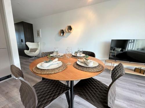 uma sala de jantar com uma mesa de madeira e cadeiras em New Selfoss Apartment - Stylish & Modern em Selfoss